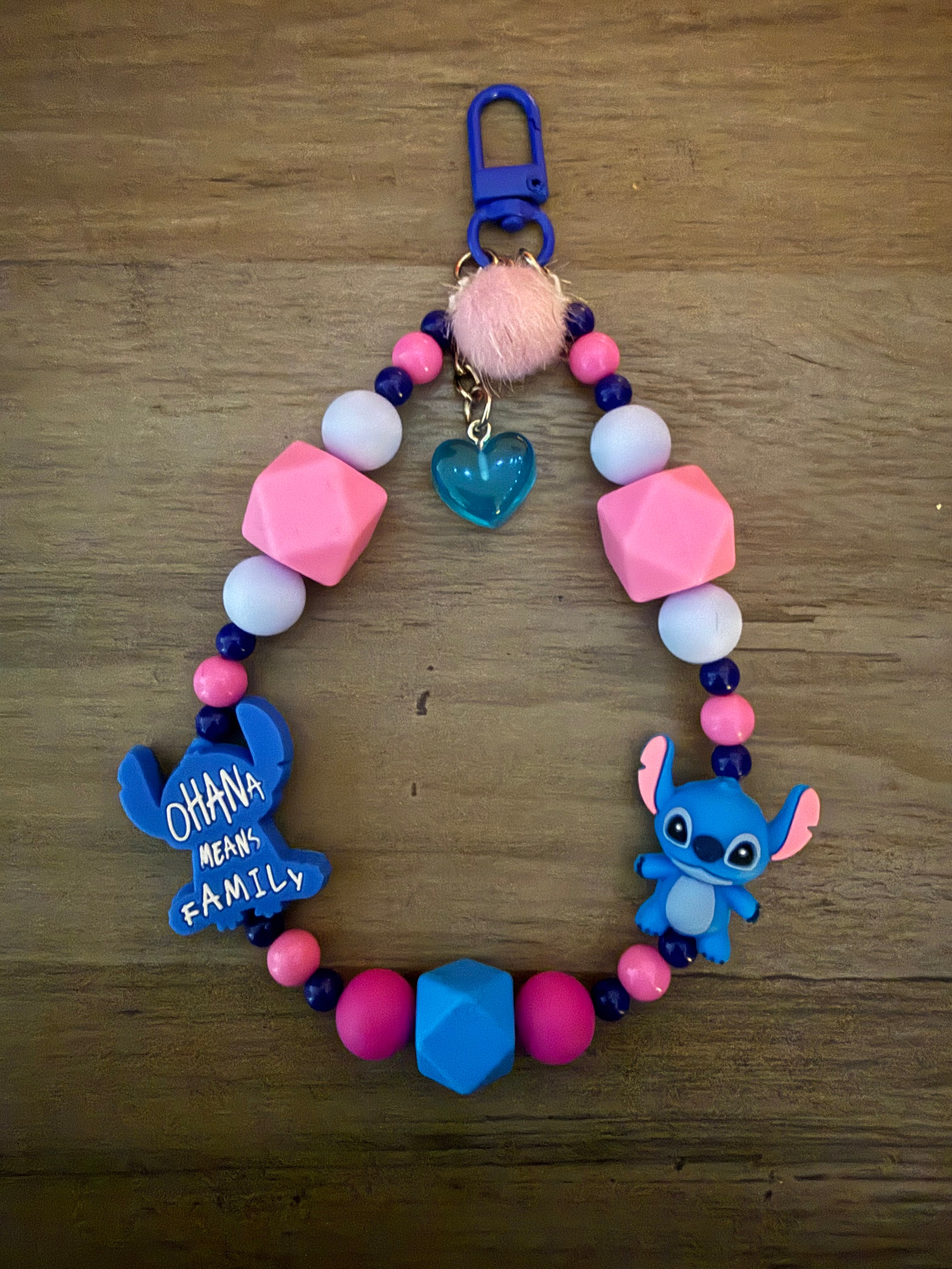 A colorful beaded wristlet keychain featuring alien characters, pink and blue silicone beads, a blue heart charm, and a pink pom-pom.