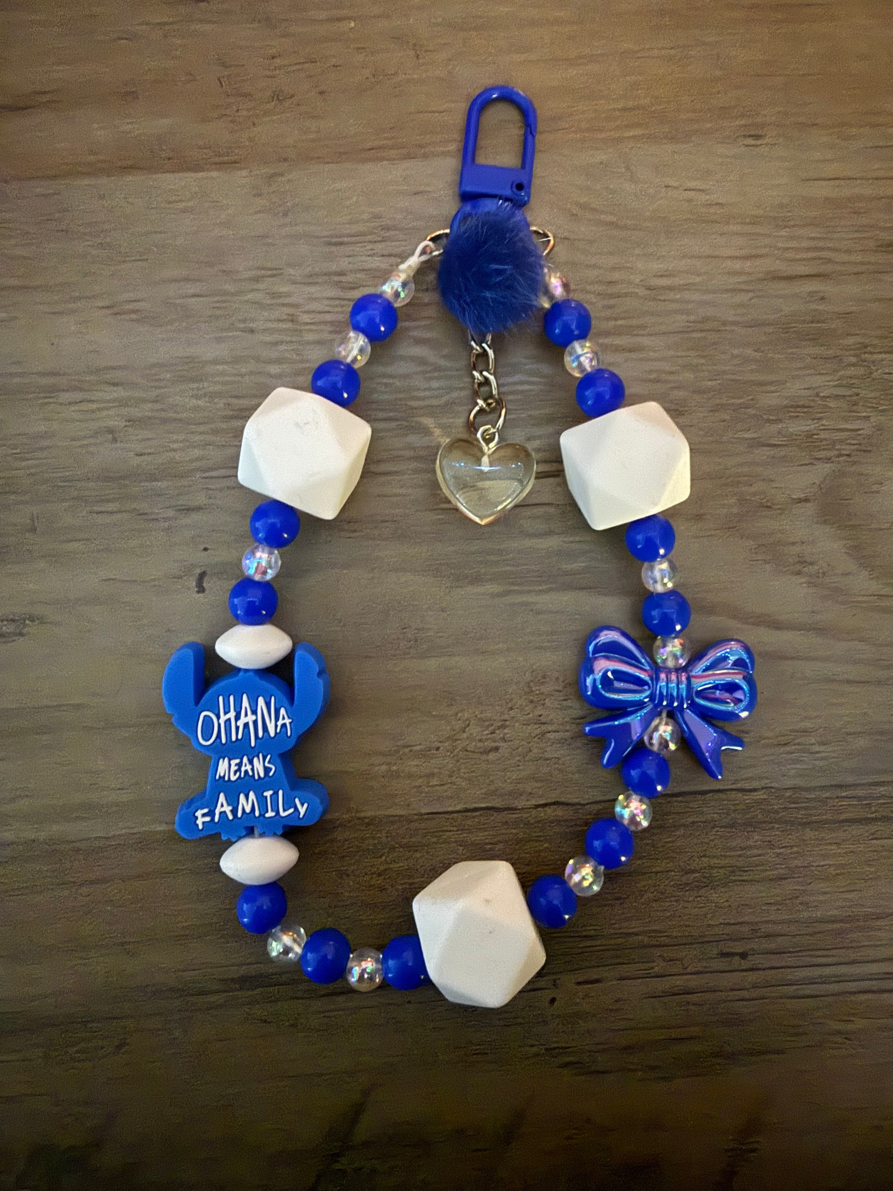 Handmade blue and white beaded bag charm featuring a "Ohana Means Family" alien silhouette, a blue bow, and a clear heart pendant.