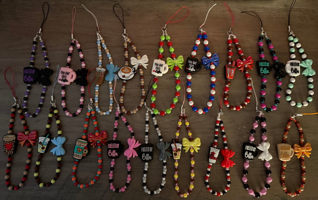 A collection of eighteen colorful beaded wristlet charms arranged in two rows, featuring various coffee-themed charms, bows, and "Fueled by Coffee" slogans.
