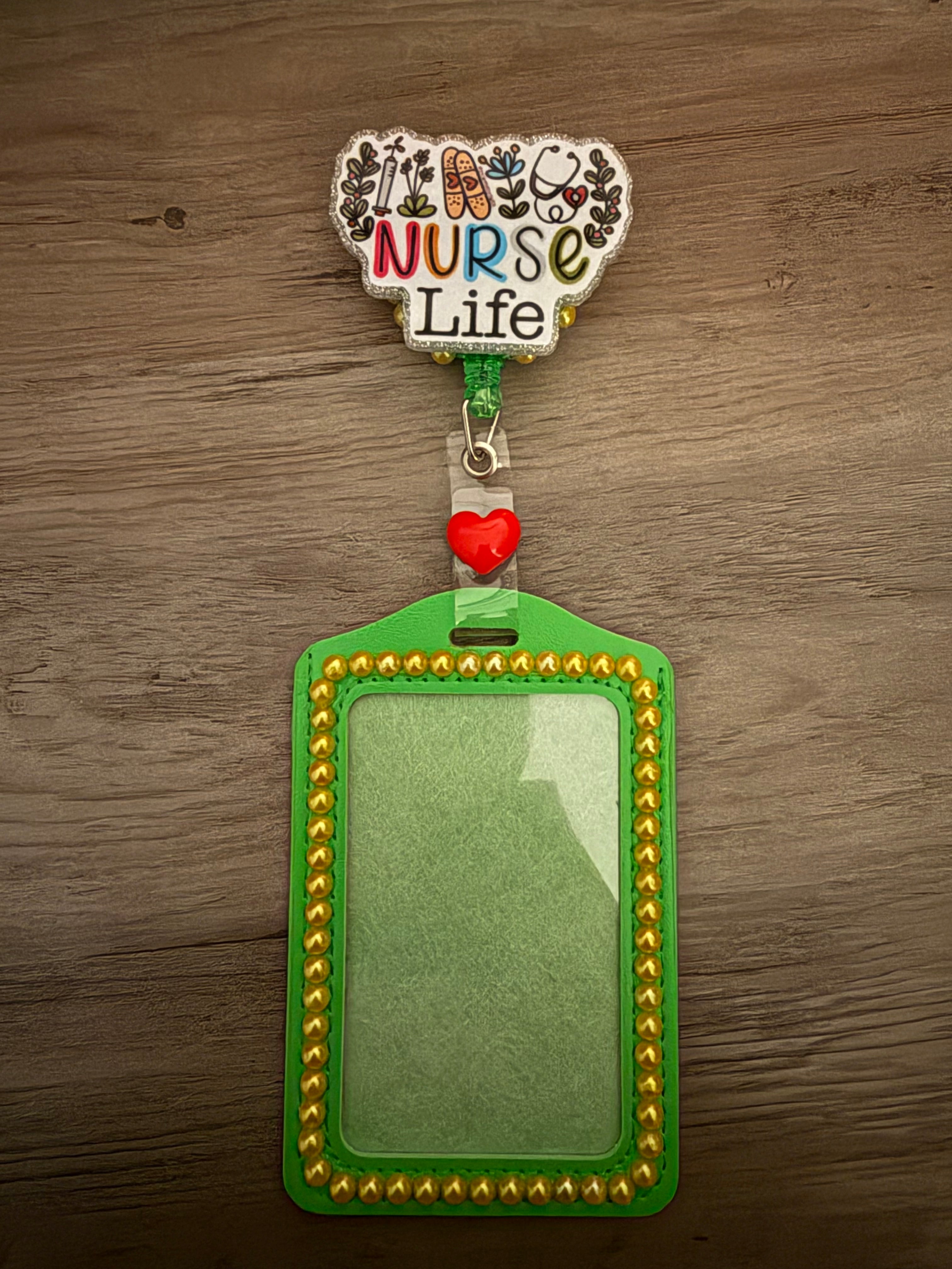 A green ID badge holder with "Nurse Life" text and medical icons, featuring gold beaded trim and a red heart accent.