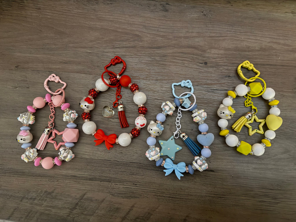 Colorful beaded keychains featuring various charms, including stars, bows, and Hello Kitty motifs.