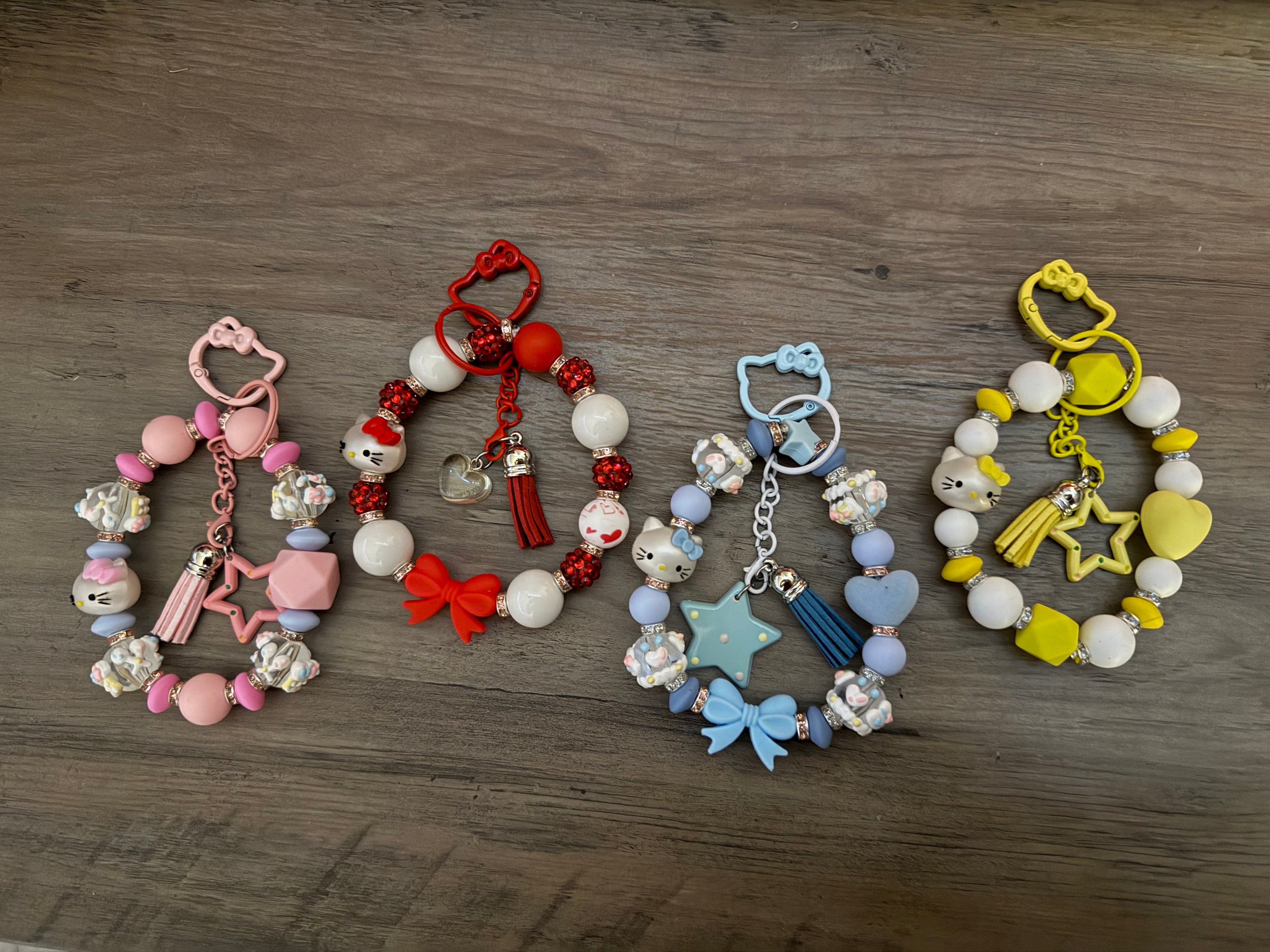Colorful beaded keychains featuring various charms, including stars, bows, and Hello Kitty motifs.
