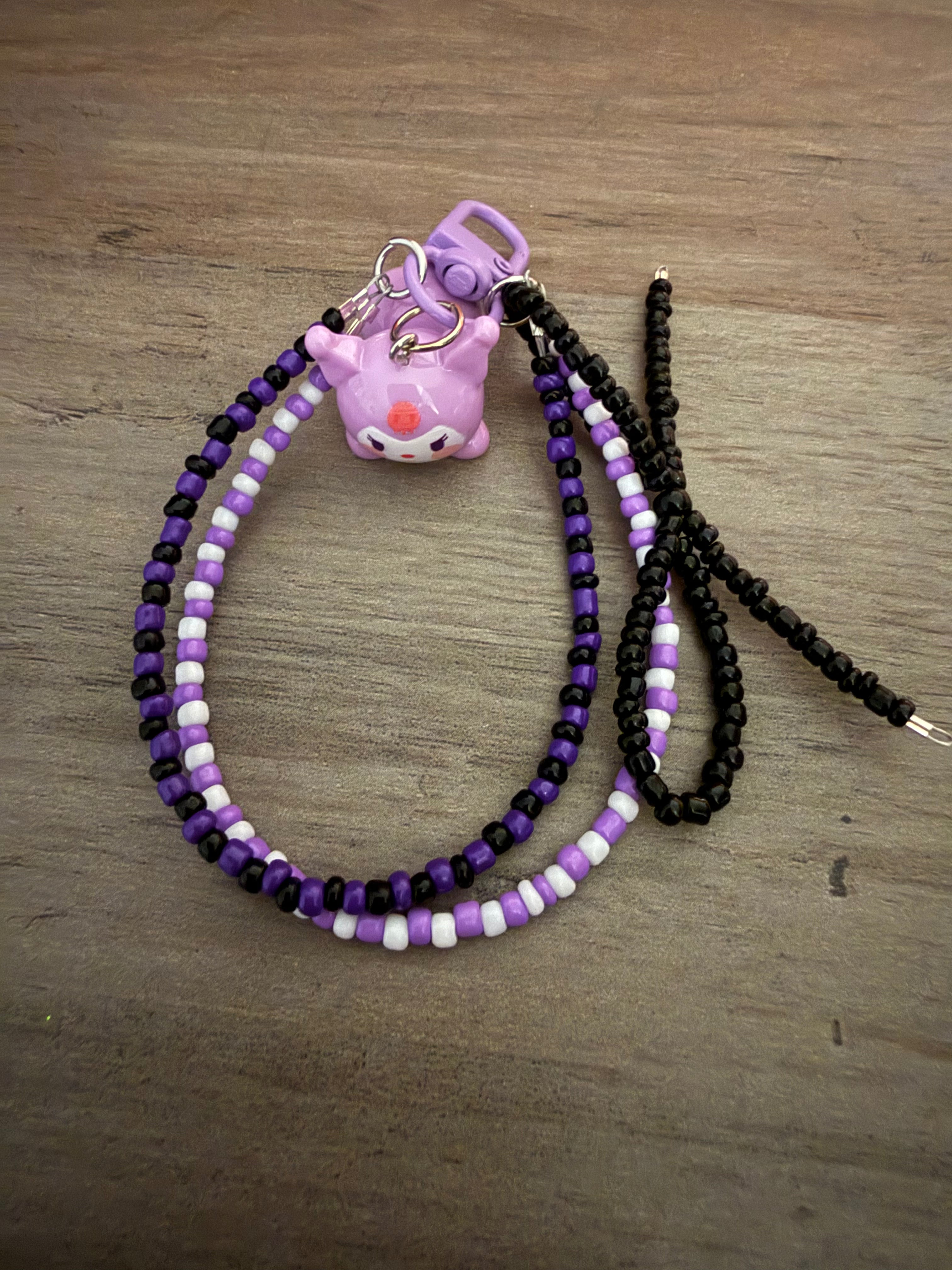 Handmade bag charm featuring a Kuromi character charm on a beaded loop of purple, black, and white seed beads.