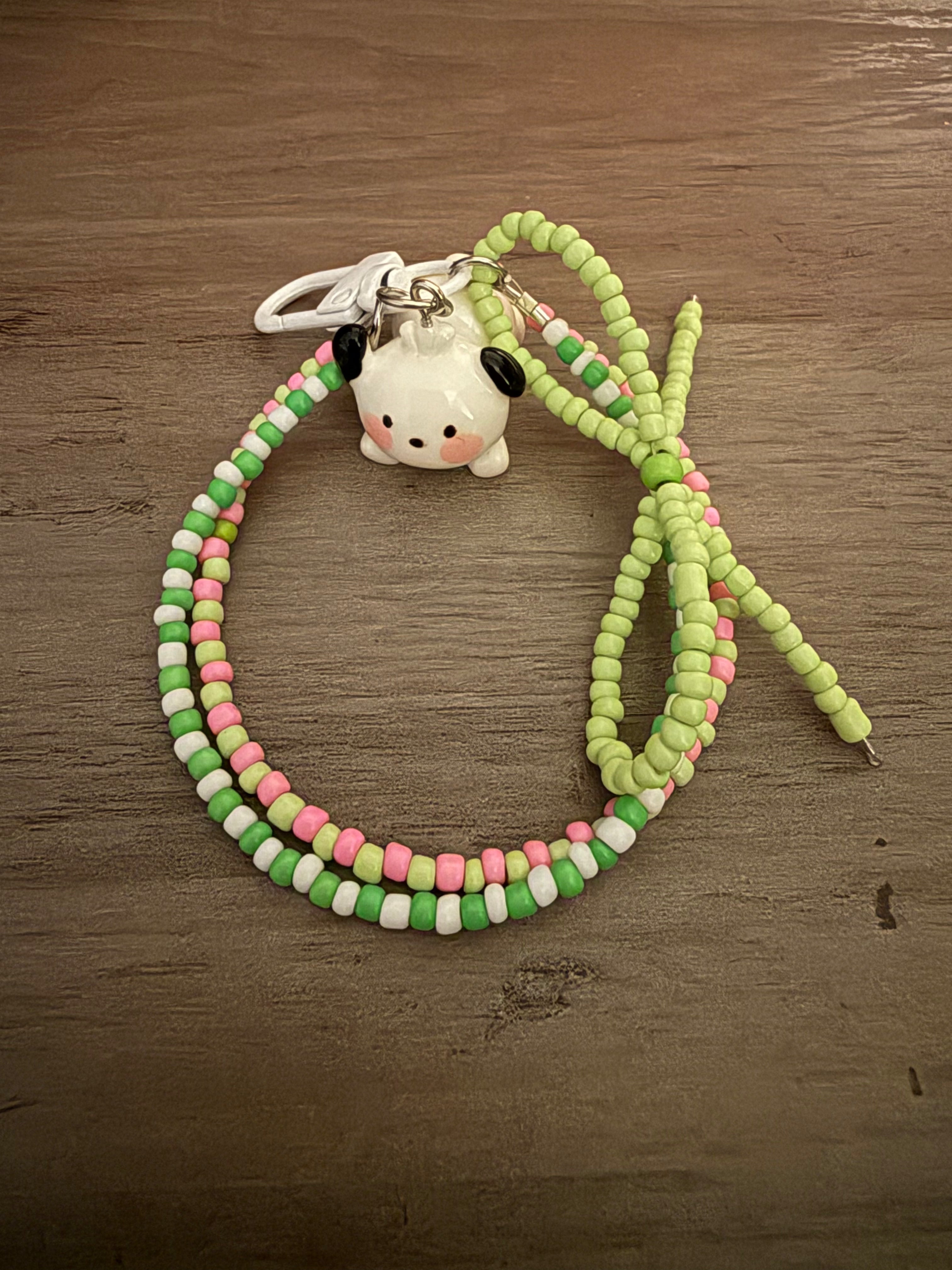 Handmade bag charm featuring a Pochacco character charm on a beaded loop of green, pink, and white seed beads.
