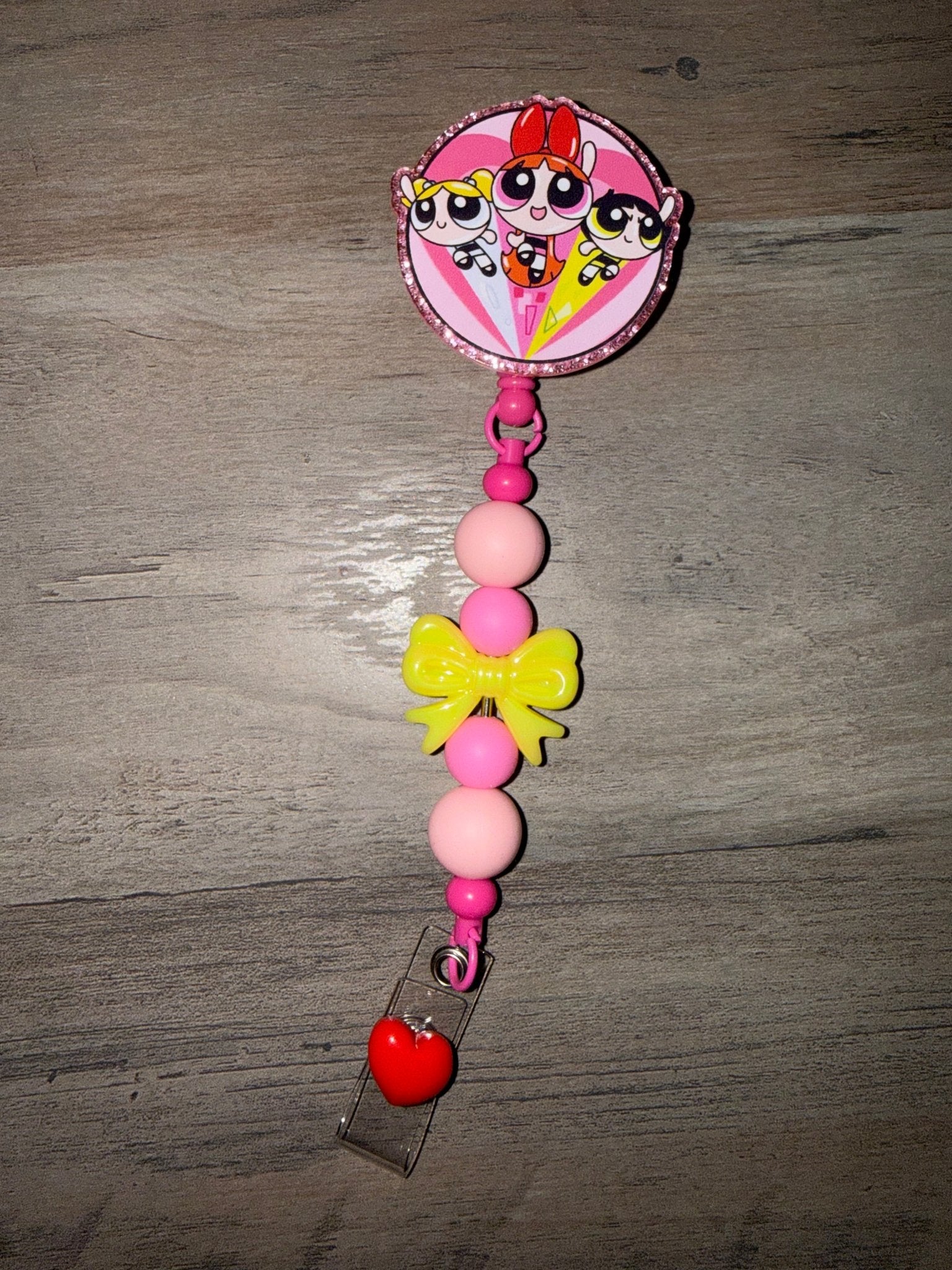 Handmade Powerpuff Girls retractable badge reel with pink and white beads and a yellow bow.