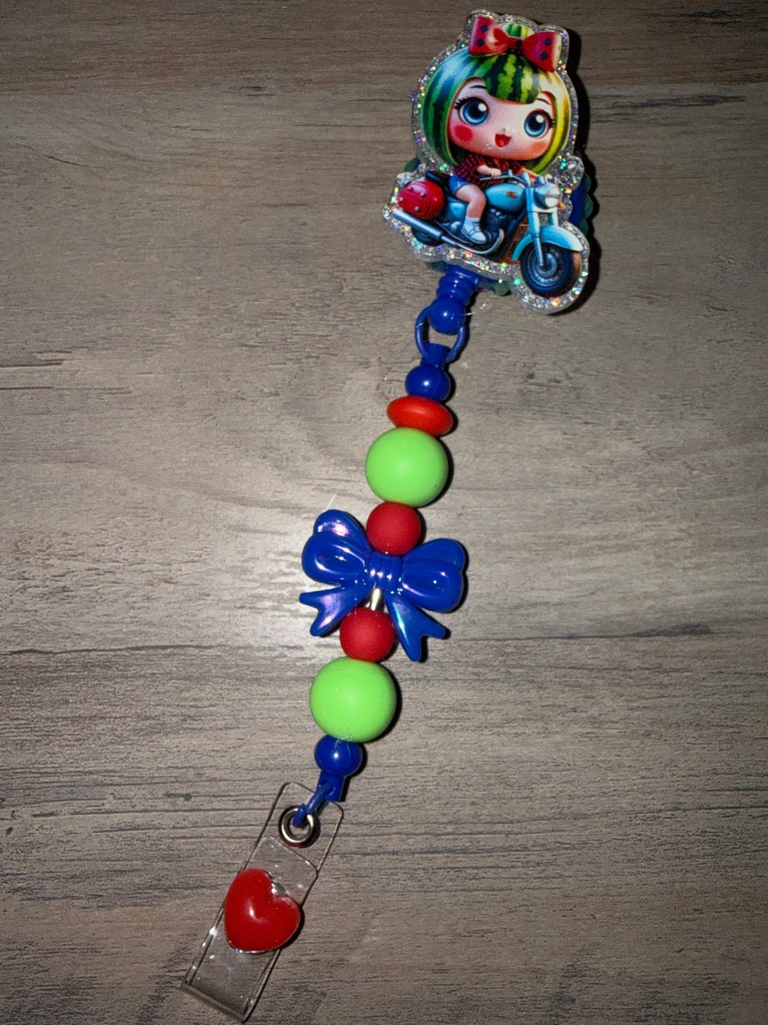 Handmade watermelon character retractable badge reel with green, red, and blue beads and a matching bow.