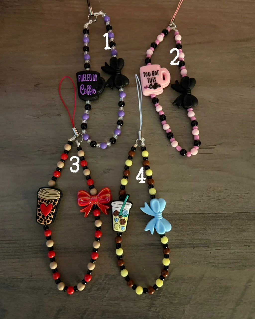 Colorful coffee-themed phone charms, featuring coffee cups, bows, and motivational phrases, all strung with vibrant beads.