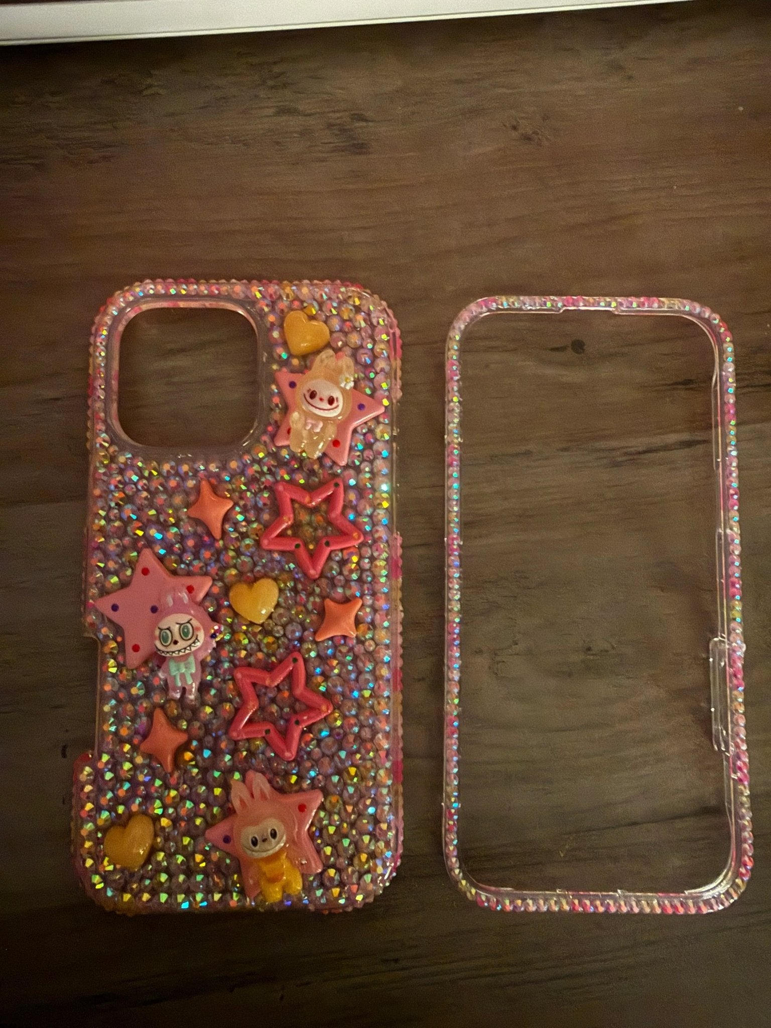 Colorful phone case adorned with sparkling rhinestones, featuring playful star and heart shapes, along with cute monster.