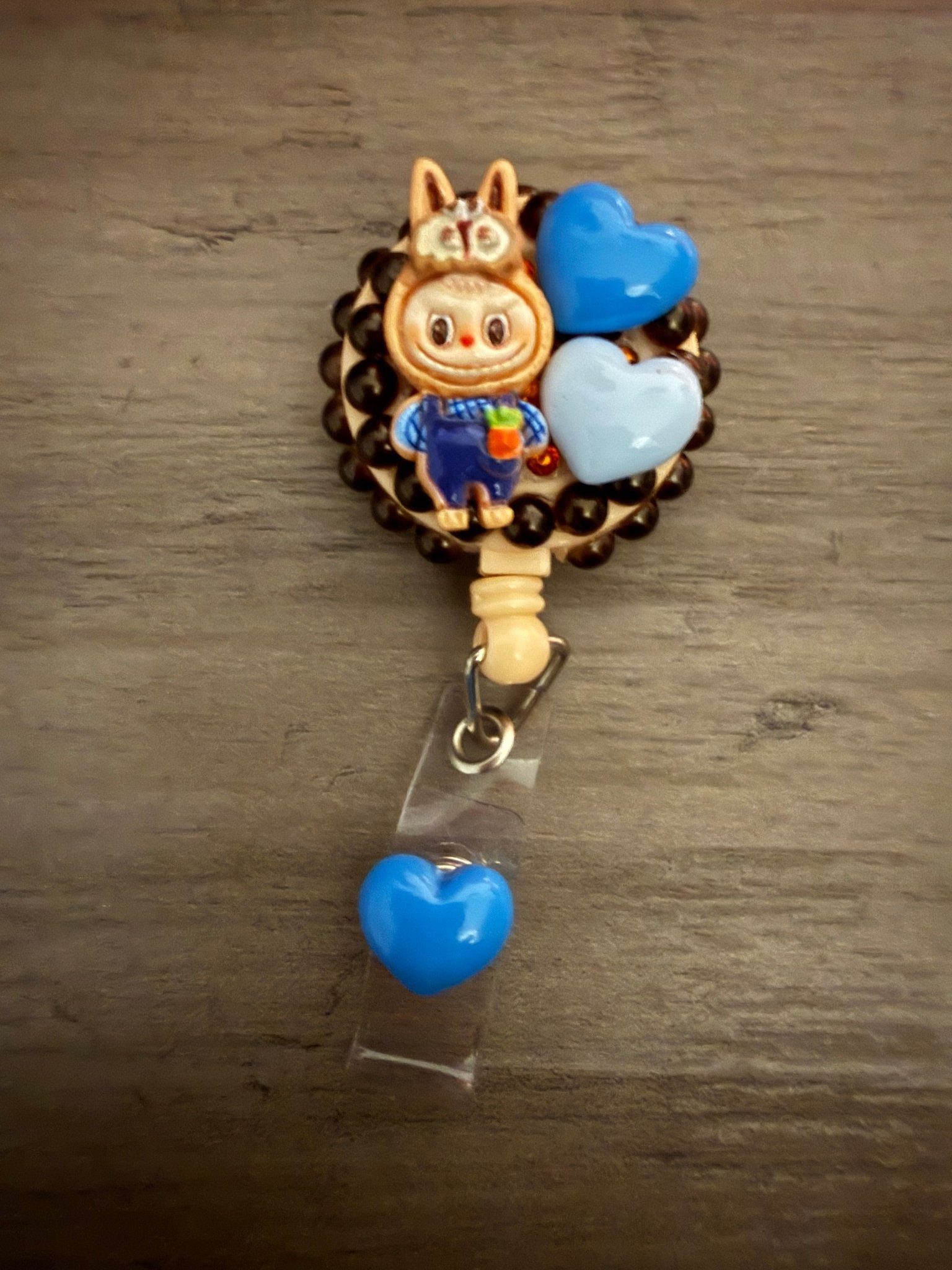 Handmade decoden retractable badge reel with a bunny character and blue heart charms on a dark beaded base.