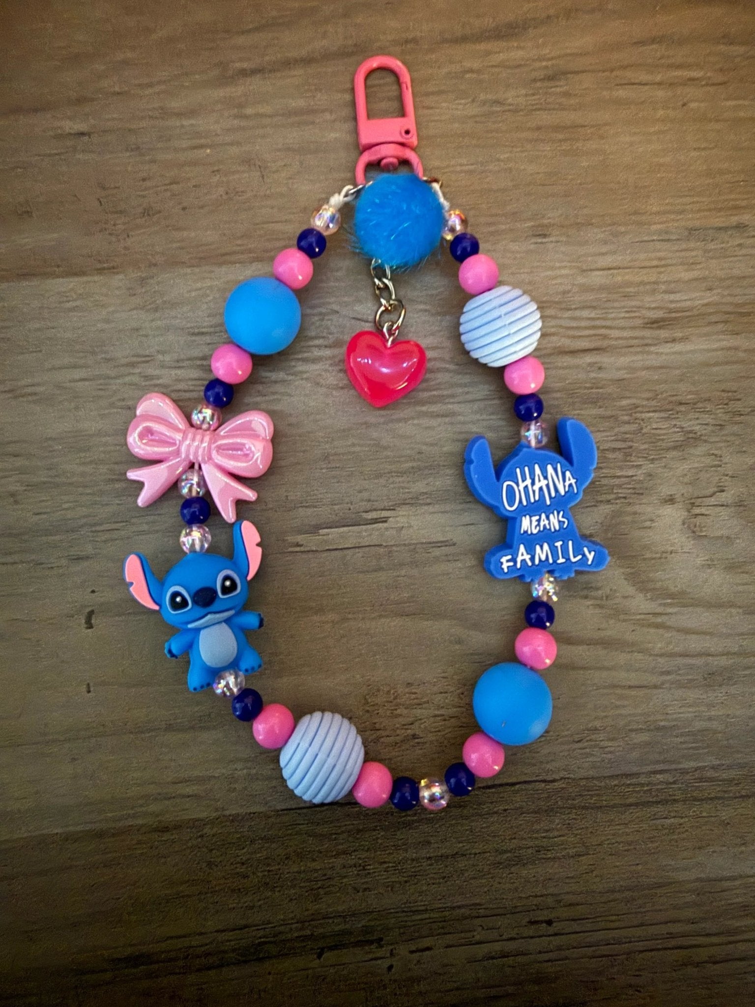 Colorful "Ohana means family" bag charm/phone charm with Stitch charm, heart, bow, and various beads.
