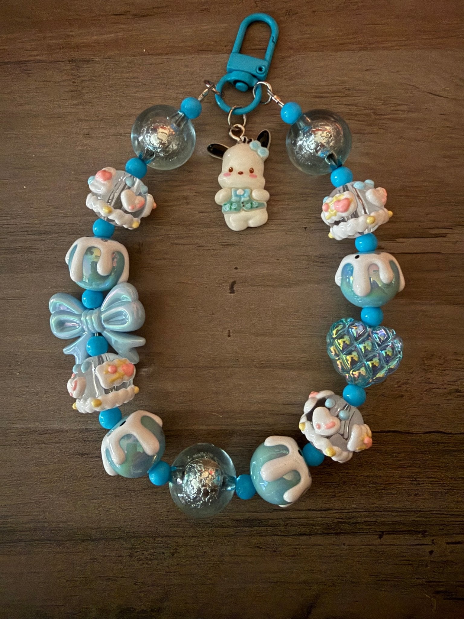 Handmade Pachacco beaded bag charm with blue and white decorative beads and a blue clasp.