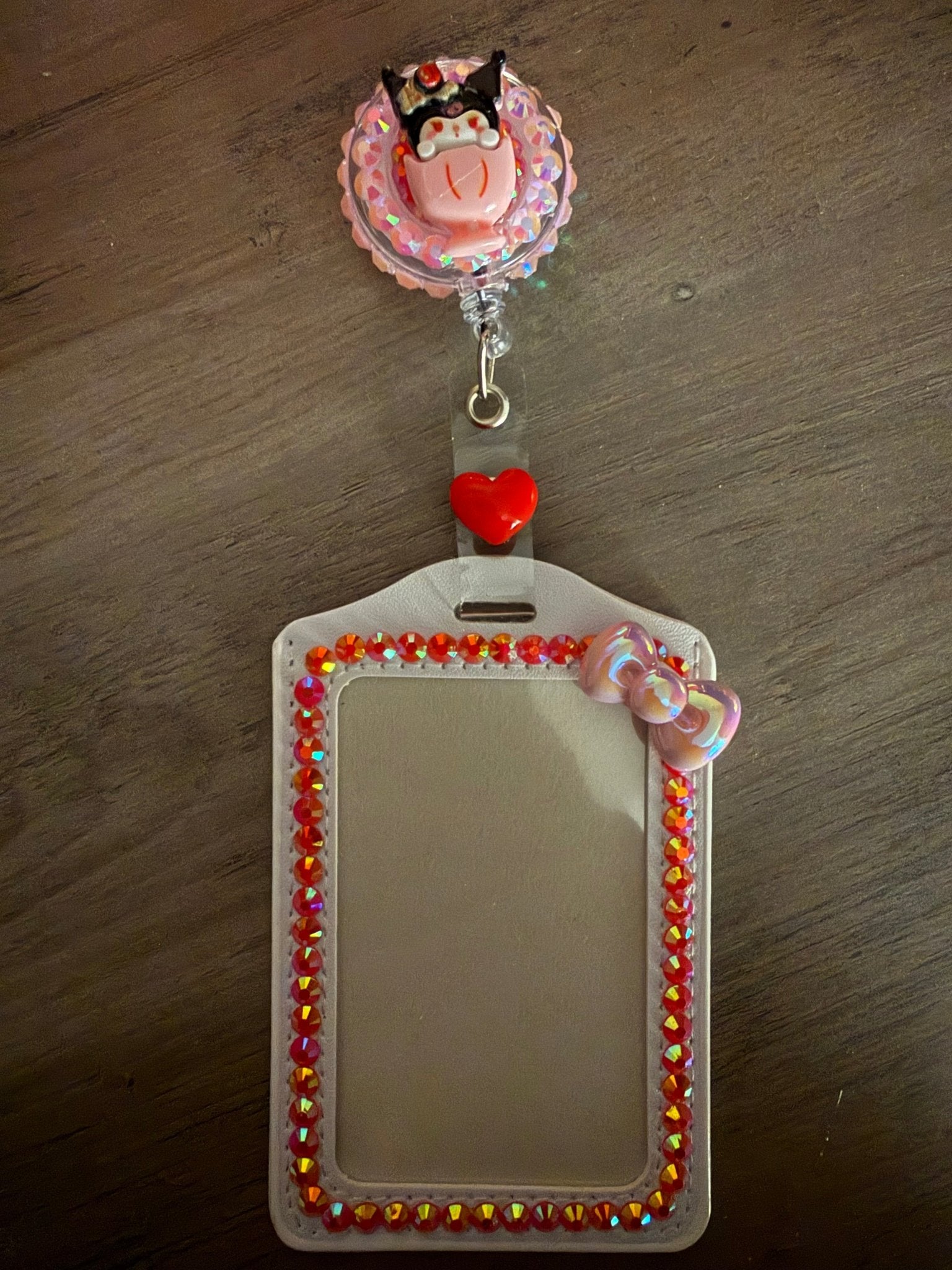 Handmade Kuromi ID holder with a white rhinestone-lined sleeve and a matching retractable character reel.