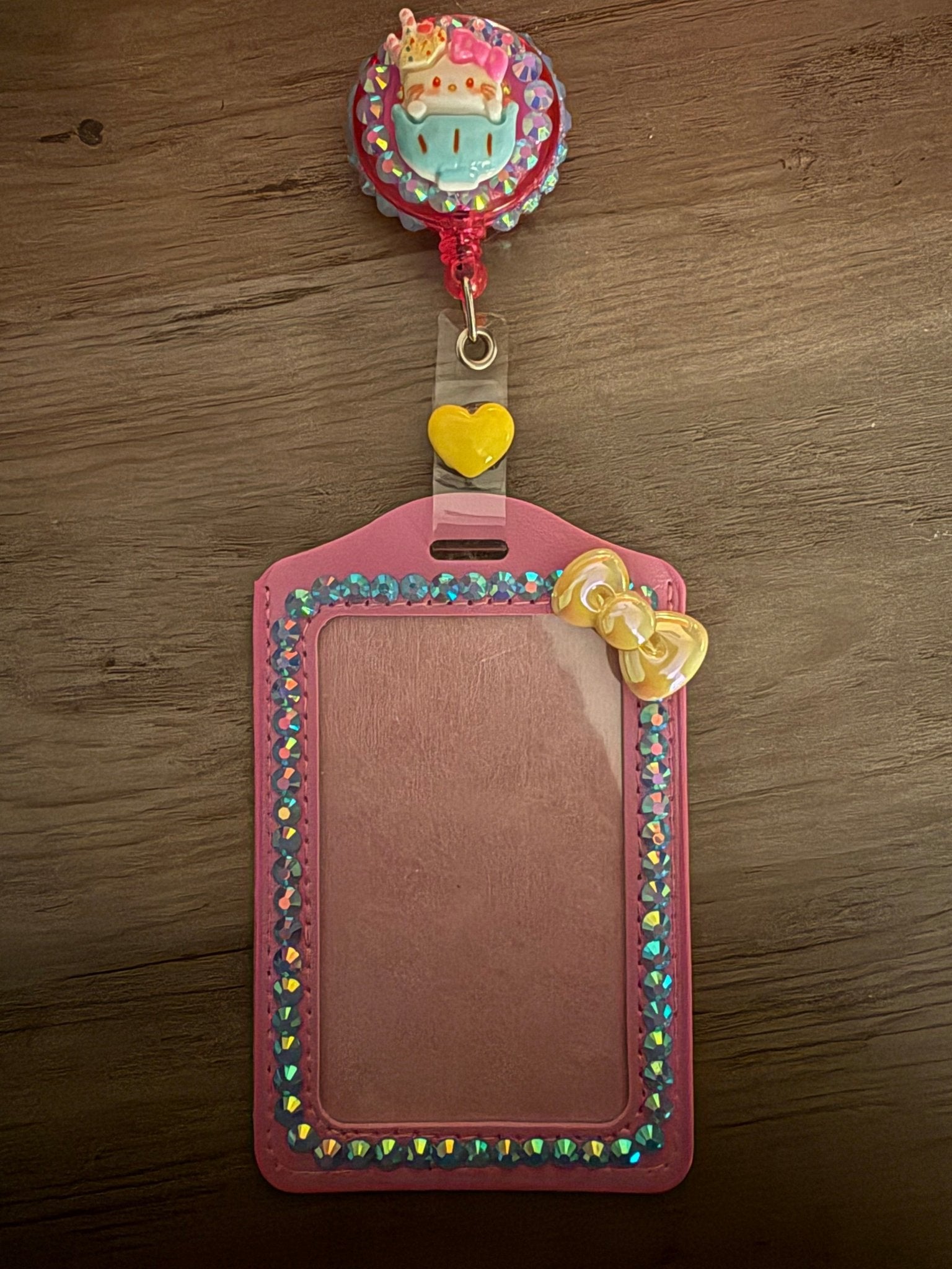 Handmade Hello Kitty ID holder with a pink rhinestone-lined sleeve and a matching retractable character reel.