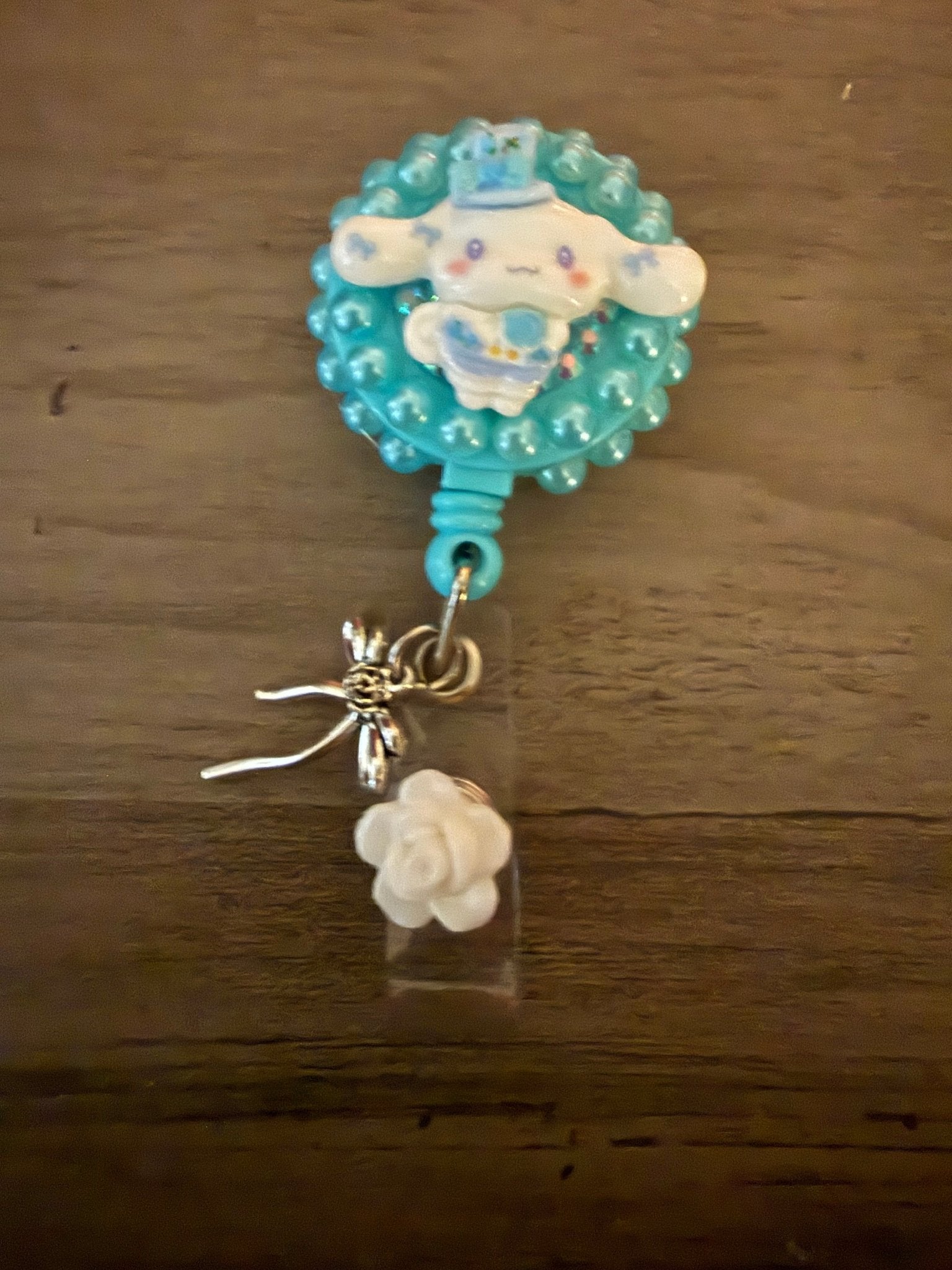 Handcrafted Cinnamoroll decoden badge reel with blue pearls, a silver bow, and a white rose charm.