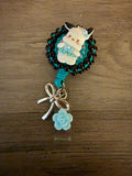 Handcrafted Pachacco decoden badge reel with black beads, a silver bow, and a light blue rose charm.