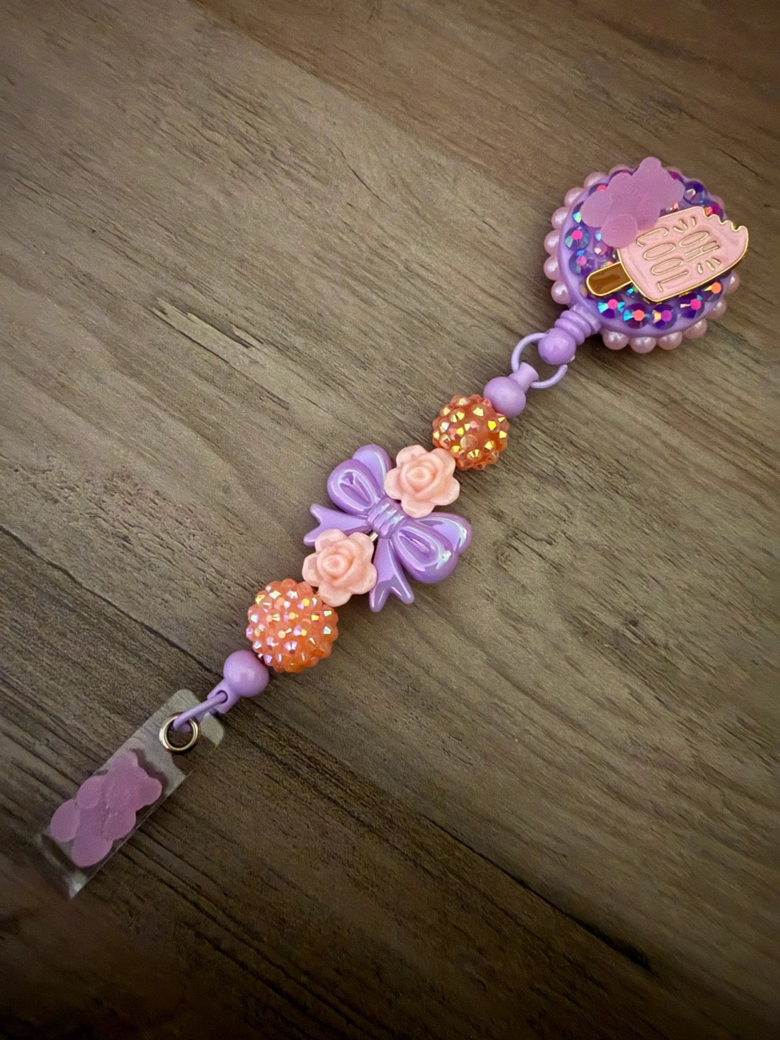 Colorful badge reel, featuring a playful ice cream design, pink and orange beads, and flower and bow accents.