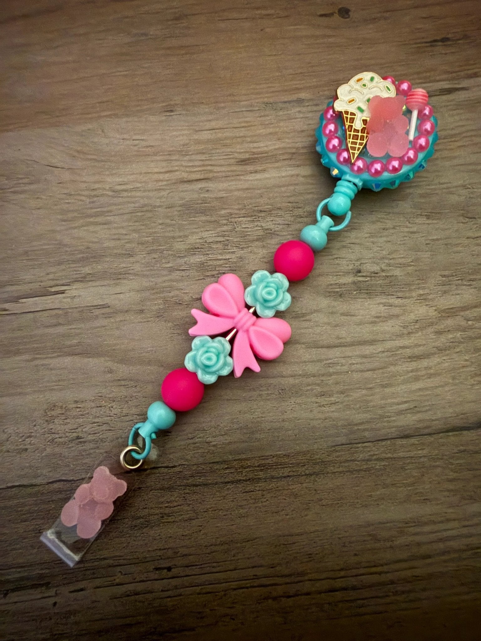 Colorful badge reel with an ice cream design, featuring pink and turquoise beads, flower accents, and a pink bow.